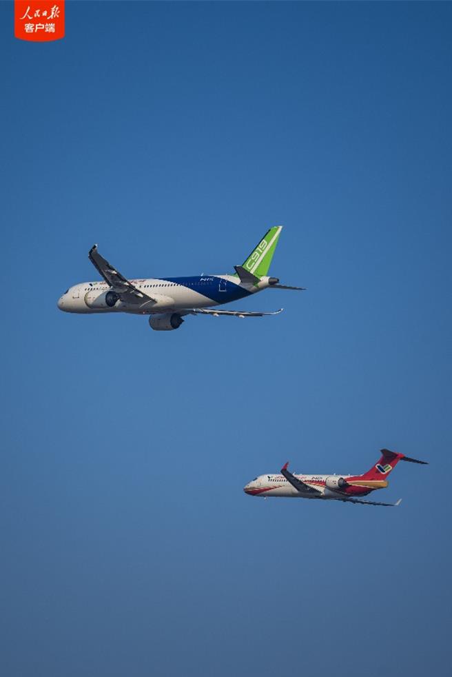 陆国产ARJ21和C919客机首次双机编队飞行表演。（人民日报用户端）