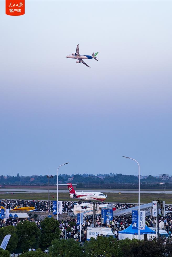 陆国产ARJ21和C919客机首次双机编队飞行表演。（人民日报用户端）