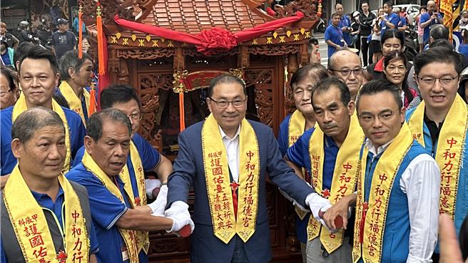新北市長侯友宜與同黨的立委洪孟楷、張智倫走在隊伍前排一同扛轎。（賀培晏攝）
