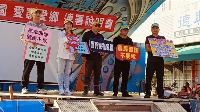 芳苑鄉永興村反對陸域風機自救會成員手持標語，表達反對立場。（葉靜美攝）