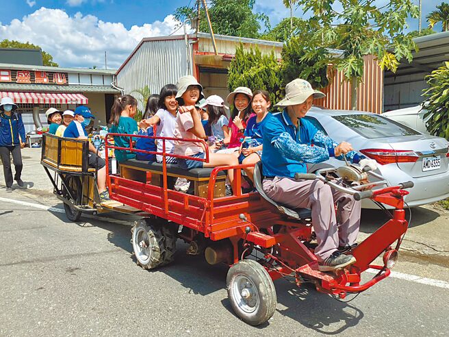 參加大埔社區夏令營的小朋友興奮地搭搬運車下田，開車的是理事長張和賢。（古坑鄉大埔社區提供／周麗蘭雲林傳真）
