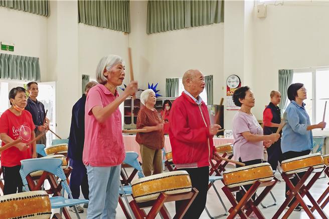苗栗縣西湖鄉高埔村4日啟用 「醫事C巷弄長照站」，20多名長者並以打太鼓方式歡慶新據點啟用。高埔村醫事C長照站融入客家文化特色，設計「曼丁鼓舞樂長青」課程，透過音樂與舞蹈的五感體驗，讓長者在熟悉的社區環境中持續享有健康快樂的生活。（呂麗甄攝）