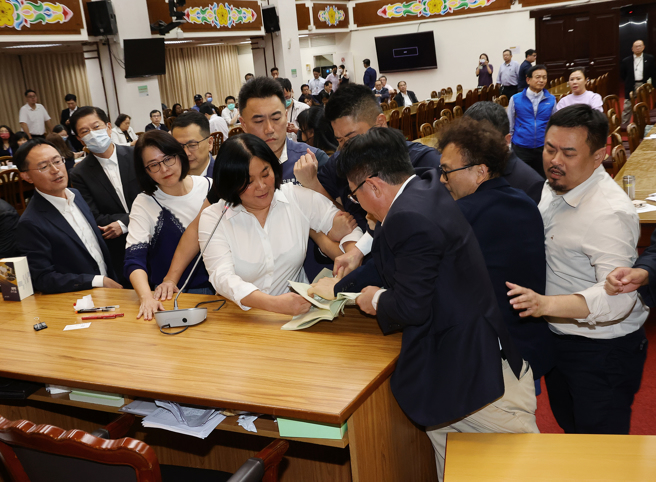 立法院财政委员会4日审查财政收支划分法修法草案等案，会议晚间继续进行时，国民党召委陈玉珍（前中）欲强行逐条闯关，引发民进党立委不满，民进党立委郭国文（右三）抢陈玉珍手中的财划法修法草案资料，阻止陈玉珍念条文。（刘宗龙摄）