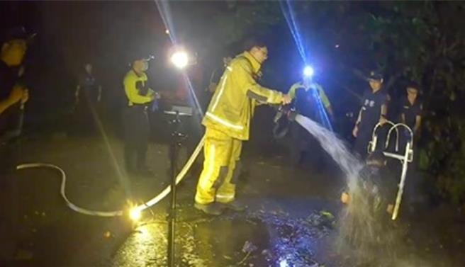 基隆有一名陳姓通緝犯4日遭警方查獲，因掙脫受傷戒護就醫時，竟趁隙逃脫躲到化糞池裡，圖為消防人員幫陳男沖洗糞便。（基隆市警察局提供／徐佑昇基隆傳真）