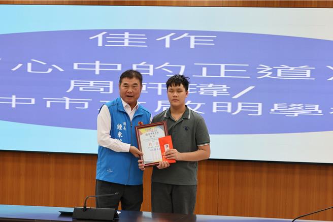 苗栗县政府举办「音乐廉想」廉政歌曲徵选比赛，5日苗栗县长锺东锦颁奖给获得佳作的台中启明学校同学周轩玮。（谢明俊摄）