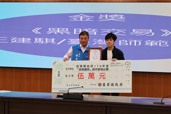苗栗县政府举办「音乐廉想」廉政歌曲徵选比赛，5日苗栗县长锺东锦颁奖给冠军得主师大学生王建骐。（谢明俊摄）