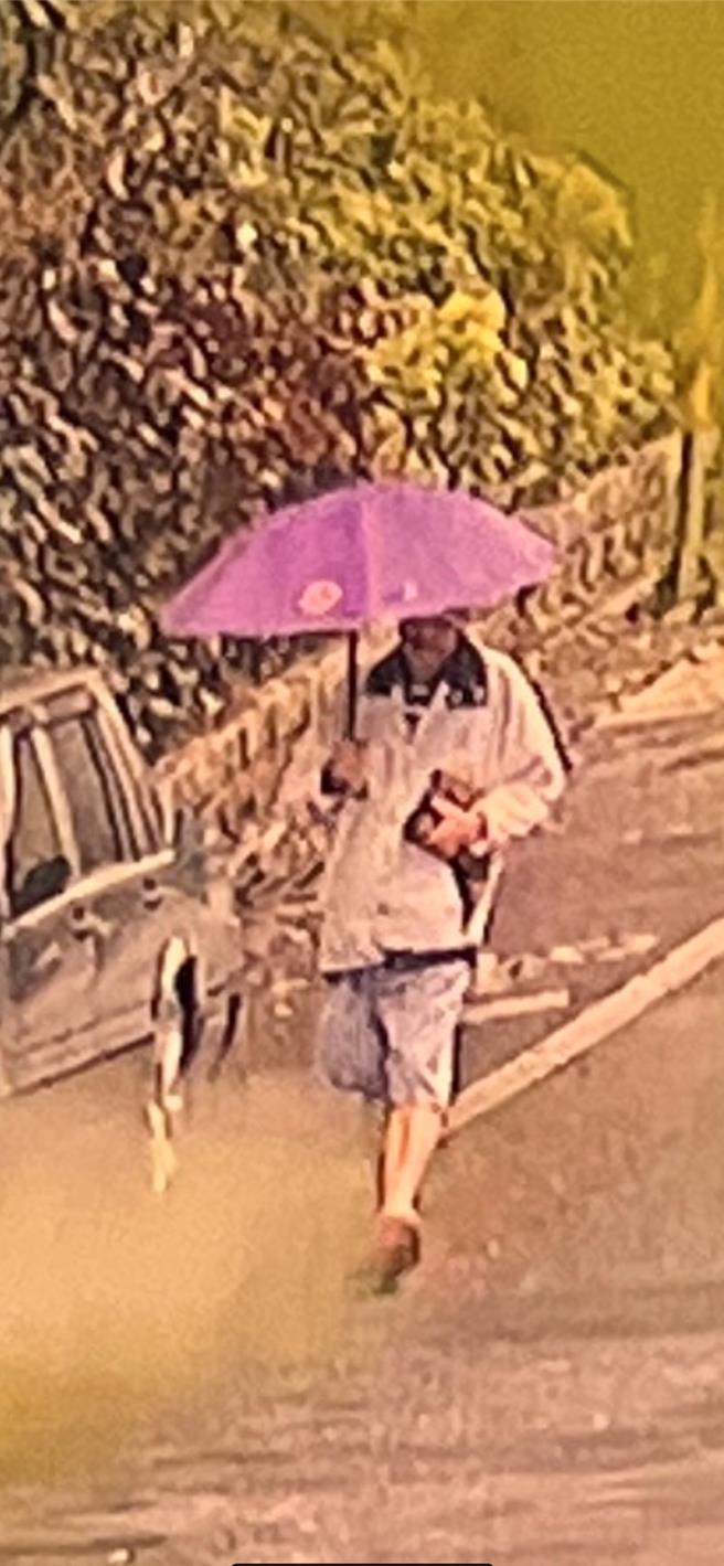 林爸爸5日上午拿着雨伞走出家门。（林叶亭提供）