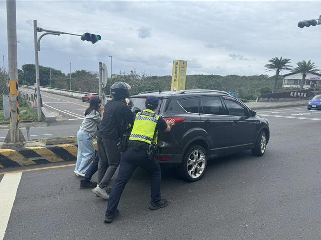 警民合力推車脫困。（金山警分局提供）