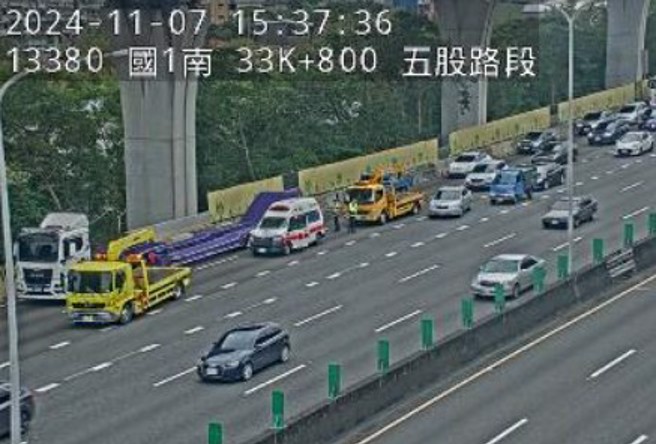 新北市消防局的救護車疑似前方車輛緊急煞車，不慎追撞導致車頭凹損，副駕駛嘴唇受傷。（翻攝國道1968監視器）