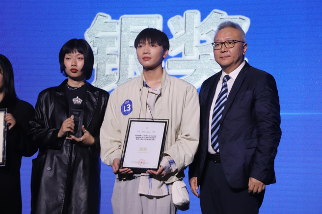 第三屆長江杯金裳獎銀獎得主實踐大學時尚設計學系的曾微凱(中)、鍾欣庭(左)。(攝/劉安婕)