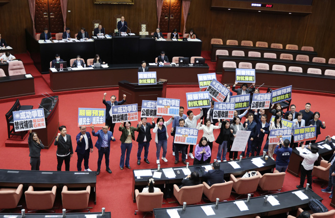 在立法院長韓國瑜8日在院會中宣布朝野協商結果後，立委高金素梅手拿「成功爭取，禁伐補償每公頃6萬元」的標語，在議場內錄影記錄。（姚志平攝）