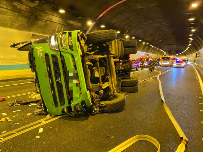 聯結車因不明原因，失控撞施工護欄後翻車，整台車橫躺在路中。（蕭宥彤翻攝）