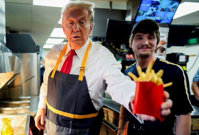 川普20日到麦当劳打工、亲手炸薯条，他尤其惊讶可用勺子装盛薯条，全程不必沾手，直呼「相当专业」。（路透社）