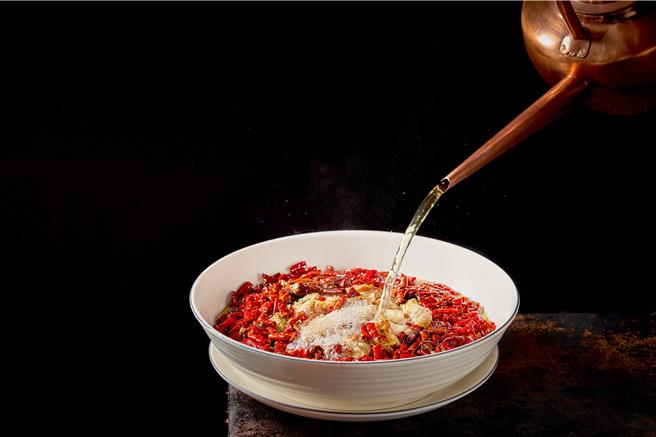 「沸腾时令现捞鱼」上桌时浇淋以由多种辛香料、姜及葱泡发成的滚烫热油，透过高温油淋将麻辣鲜香味完全浸入鱼肉当中，喷香诱人。(台北晶华酒店提供)