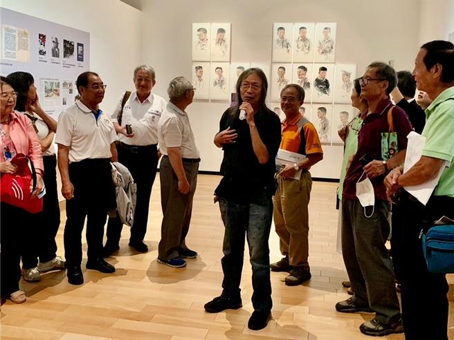 洪根深向到场来宾说明他的画作内容及创作理念。（郭良杰摄）