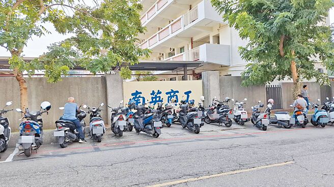 台南市一家龍頭百貨周年慶期間，周遭違停亂象層出不窮，連學校側門畫紅線仍有一堆百貨客人停放機車。（程炳璋攝）