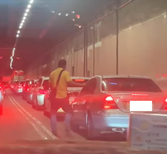 昨天半夜北市基隆路地下道大塞车1小时，有民眾气得走在车道上，拍打别人的车窗。（翻摄自 陈宥丞脸书）