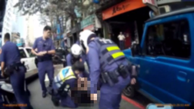 車輛自撞人行道後，警方立即上前將駕駛拉下壓制逮捕。（翻攝畫面）