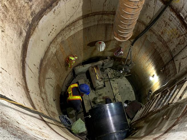 施工人員將鋼環推入地底，準備進入鋼環內進行施工。（水利局提供）