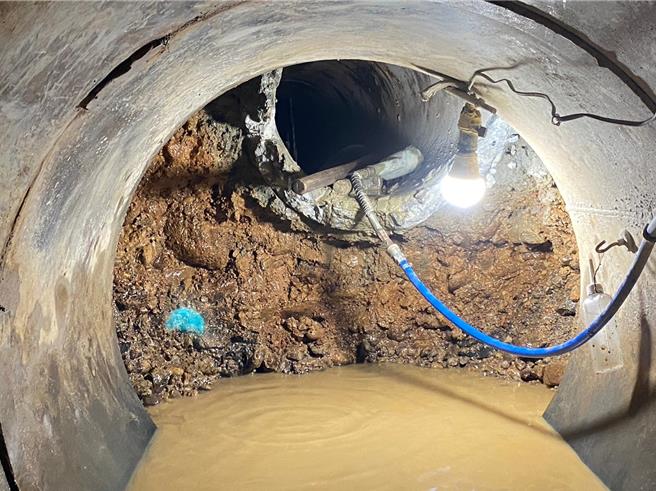 施工人員進入直徑80公分鋼環中，以人工挖掘排除障礙。（水利局提供）