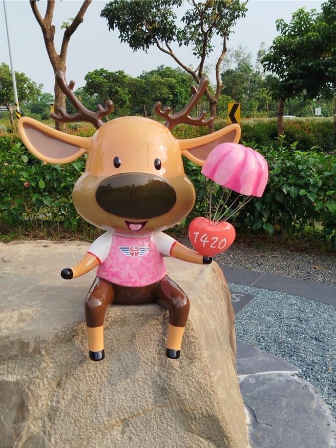 「鹿小纷」穿着缤纷亮眼的粉色迷彩装，手上拿着降落伞，形成「爱的降落」。（公路局南分局提供／罗琦文屏东报导）