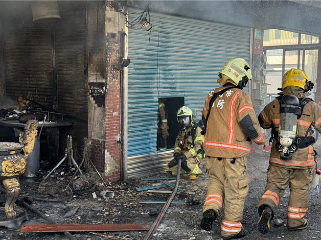 台南市学甲区八德街一间私人神坛起火，消防人员到场集结在中正、八德街交叉路口，架设水线在火场周边灭火。（读者提供／张毓翎台南传真）