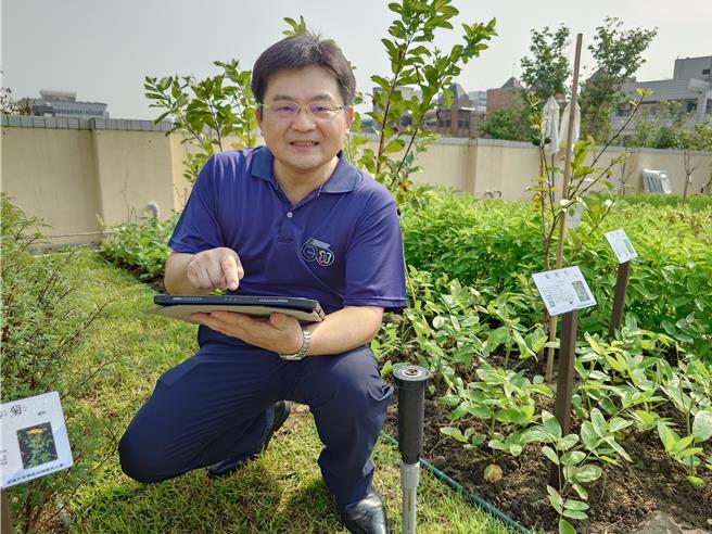 四维国小校长王渊智示范绿屋顶所用的智慧浇灌系统，能远端精准控制洒水量。（任义宇摄）