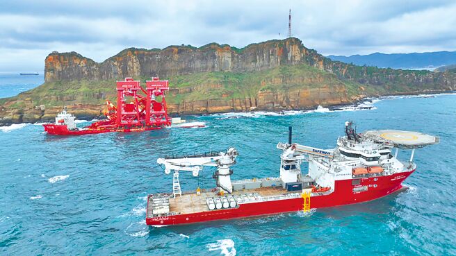 陆籍货轮「钰洲启航」（后）搁浅在新北市野柳岬海岸，交通部航港局商请东方风能公司工作船「东方建设者号」（前）投入抽油作业。（翻摄照片／张志康基隆传真）