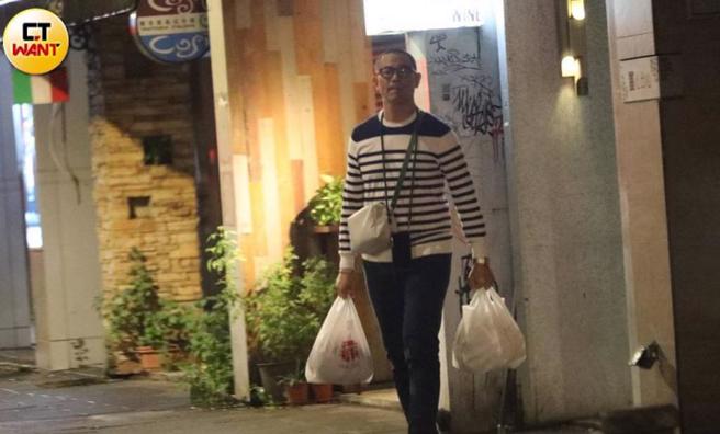江振诚提着两袋疑似是美食的袋子离开麻辣锅店。（图／本刊摄影组）