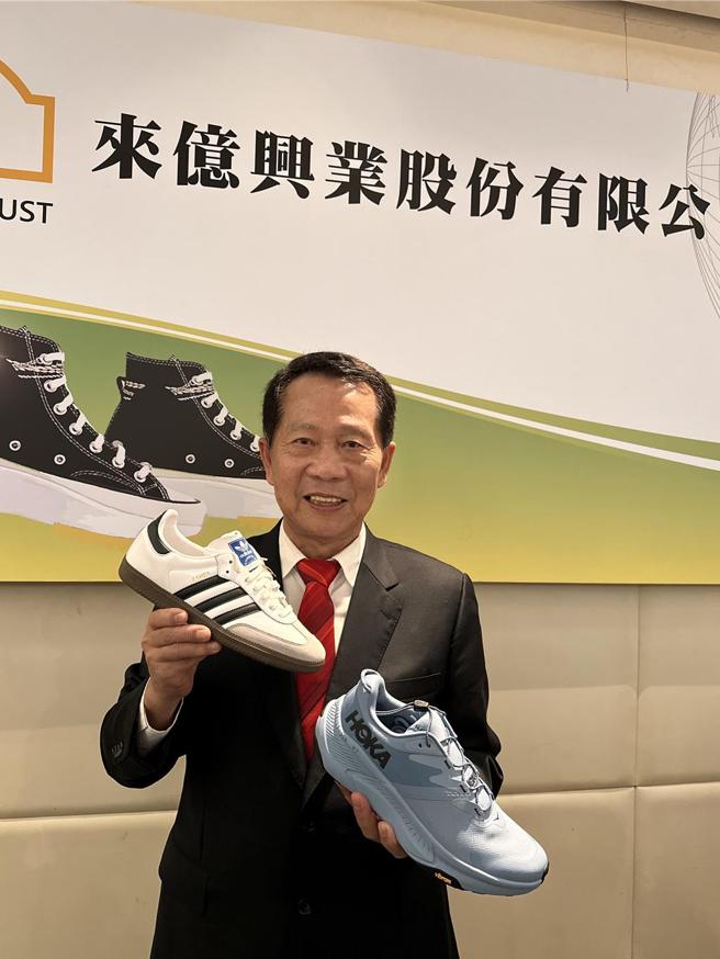 来亿-KY董事长钟德礼，手持公司代工生产的adidas品牌及HOKA品牌的鞋款。图／刘朱松