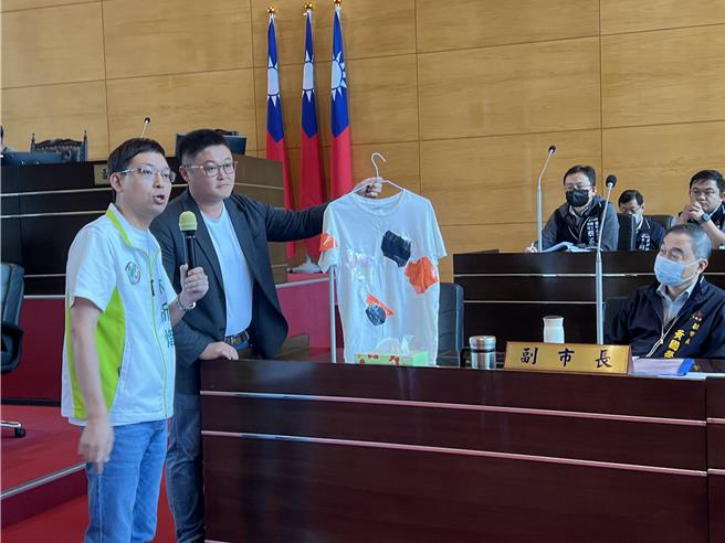 台中市議員林祈烽、施志昌12日在議會質詢痛批逢甲路況慘不忍睹，並送給副市長黃國榮一件補丁衣服。（林欣儀攝）