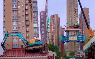 用命在赚！陆挖土机「飞上天」拆牌楼 钢绳猛晃吓翻网：真的很敢