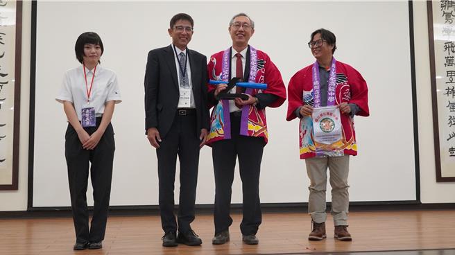 善化高中校方人员穿上鹤翔高校致赠的祭衣，和鹤翔高校人员开心合影。（宝智华摄）