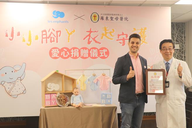 丽婴房副总经理达芮铠（左）捐赠连身衣，由圣母医院院长马汉光（右）代表受赠。（院方提供／吴佩蓉宜兰传真）