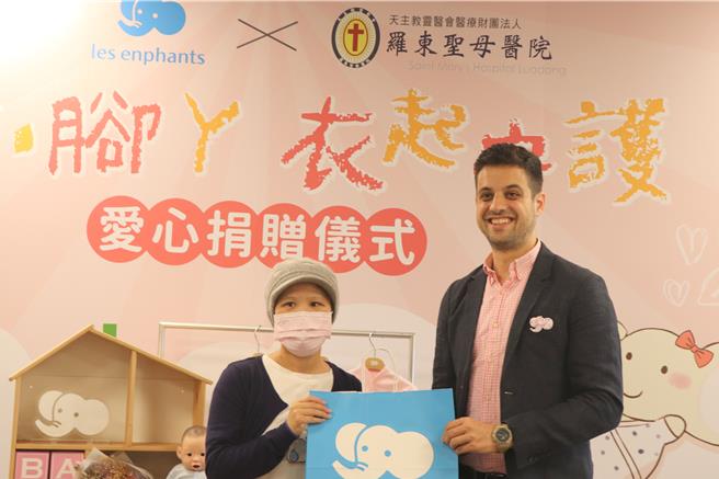 丽婴房副总经理达芮铠（右）捐赠连身衣，早产儿的妈妈陈小姐（左）受赠。（院方提供／吴佩蓉宜兰传真）