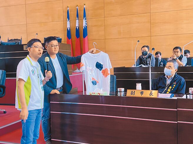 台中市议员林祈烽（左一）、施志昌（左二）12日在议会质询时，特别准备1件补丁衣服送给副市长黄国荣（右），讥讽逢甲夜市宛如「补丁夜市」。（林欣仪摄）
