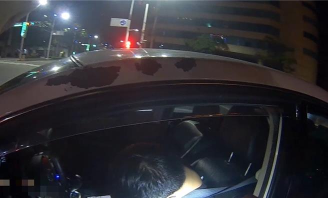 男子清晨开车，却在驾驶座倒头昏睡，警方上前盘查。（翻摄画面／纪爰高雄传真）