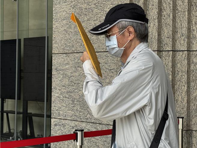 某集团前发言人侯水文出庭时持文件遮掩。(蔡依珍摄)