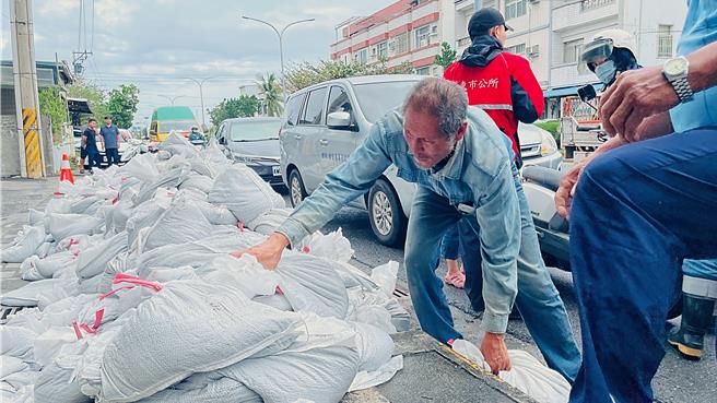 因應天兔颱風來襲，台東市公所開放民眾領取沙包防颱，民眾一邊扛沙包一邊抱怨沙包領到煩。（蕭嘉蕙攝）