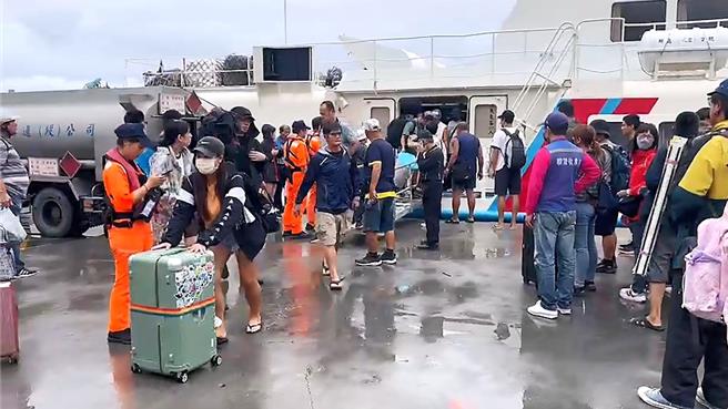 台東往返離島船班14日午後全面停航，遊客趕搭末班船返回台東市富岡漁港。（蕭嘉蕙攝）
