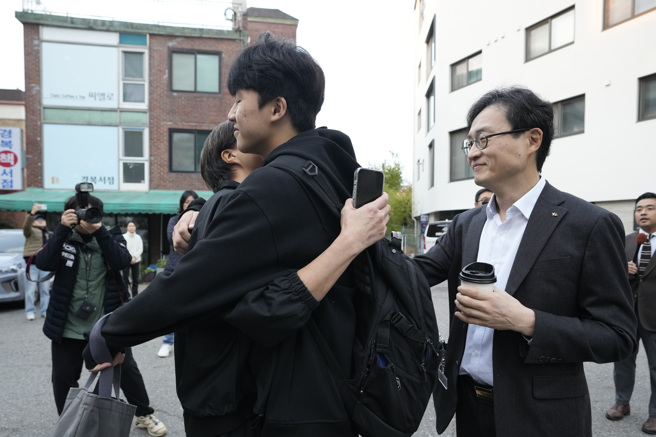 考生14日一早抵达首尔一所高中准备应试，进考场之前与母亲相拥。（美联社）