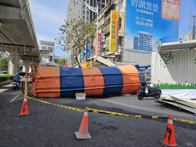 工地水泥塔倒向路面占據車道，男騎士衰遭砸右膝蓋骨折。（翻攝畫面）
