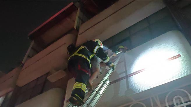 锺姓男屋主正在洗澡传出爆炸声，11岁儿子在3楼房间看到家中起火，吓得靠近窗户喊救命，消防员架梯将父子救出，火势约半小时后顺利扑灭。（高雄市消防局提供／林雅惠传真）