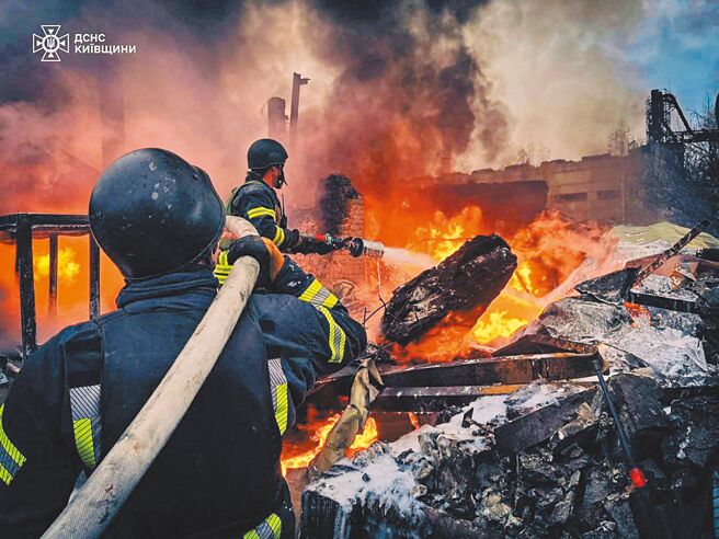 乌克兰饱受俄国飞弹摧残，基辅1处工业区13日遇袭着火，消防员全力抢救。（路透）