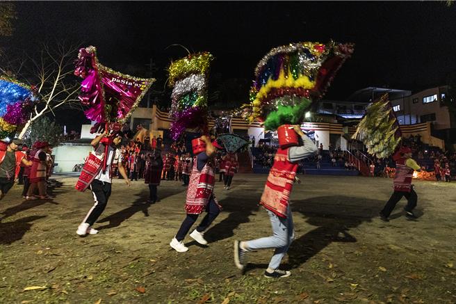 五峰乡赛夏族巴斯达隘祭典「矮灵祭」，15日晚在朱家庄矮灵祭场展开，扛肩旗的家族年青族人从山上衝到祭场绕场。（罗浚滨摄）