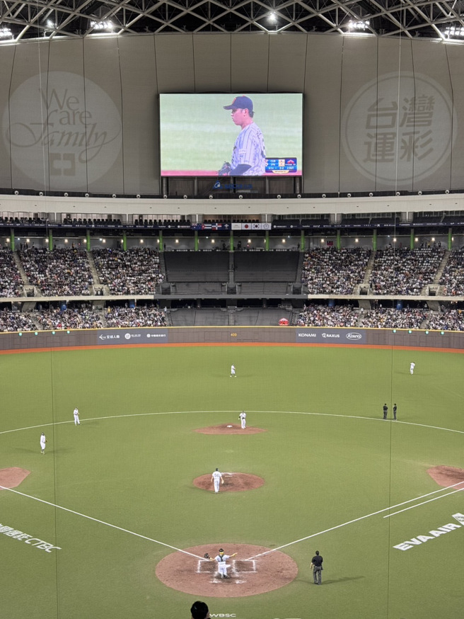 中华队9局上打击之前，台北大巨蛋的大萤幕同步直播起在天母棒球场的日本与古巴之战。（李弘斌摄）