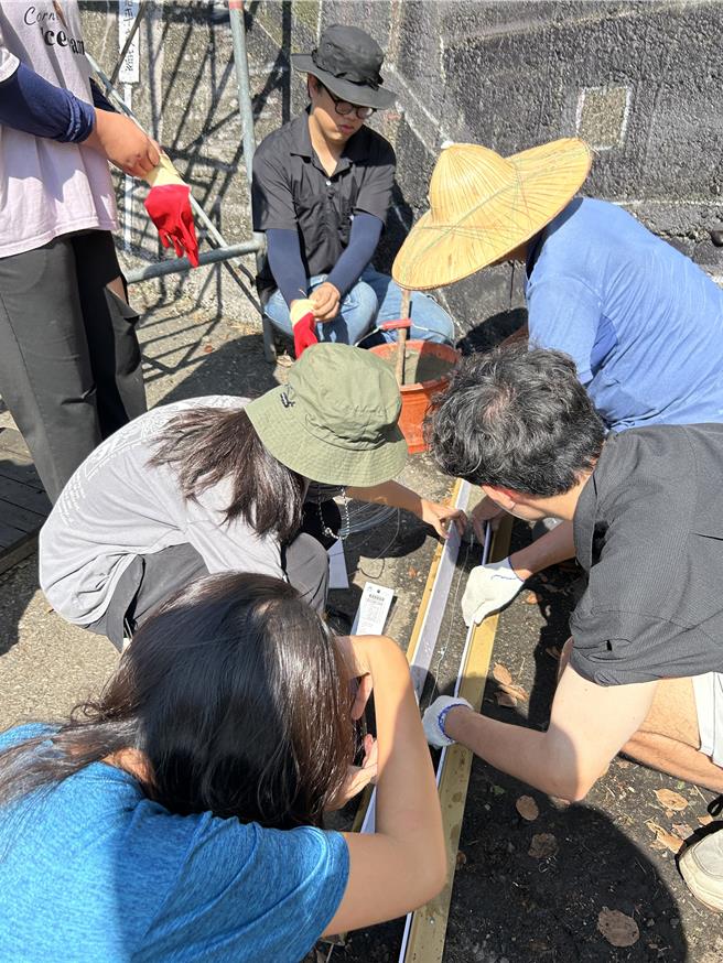 大葉大學同學與彩繪師一起施作木製鐵軌。（大葉大學提供／葉靜美彰化傳真）