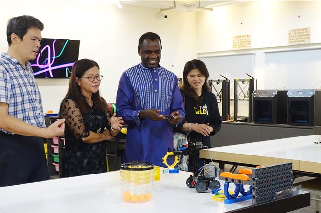 肯亞總統夫人辦公室人道救援顧問道森（右二）參訪屏東南榮國中，在創客中心體驗操作機器人。（羅琦文攝）