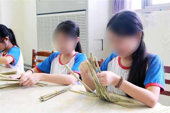 三芝圖書分館教小朋友用茭白筍廢殼製作筆筒、書籤、杯墊、置物籃等日常用品。（王揚傑攝）