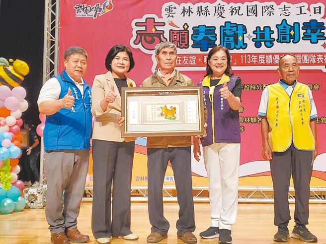 云林县府17日表扬563名志工，县长张丽善（左二）颁奖给耆老志工典范、88岁褒忠国小退休校长翁振文（中）。（周丽兰摄）